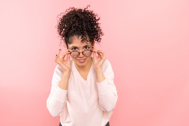 Front view of young woman on pink wall