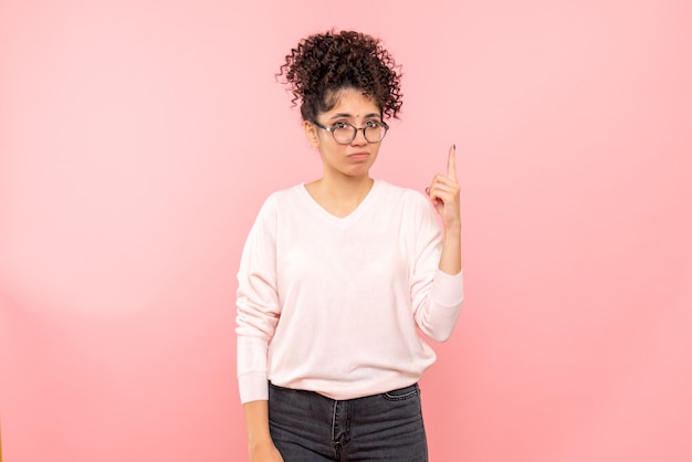 Front view of young woman on pink wall