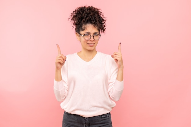 Free photo front view of young woman on pink wall