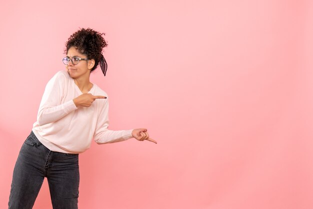 ピンクの壁に若い女性の正面図