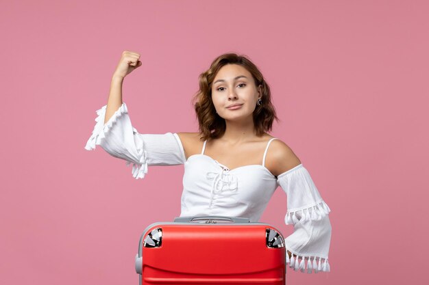 Front view of young woman posing on pink wall