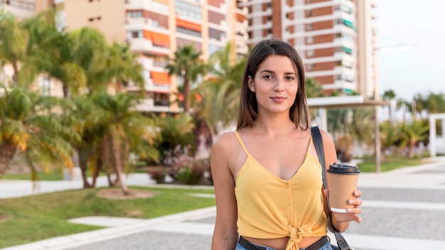 Free photo front view young woman posing with coffee cup