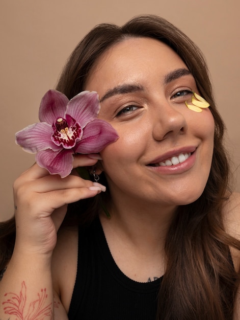 Free photo front view young woman posing with flower