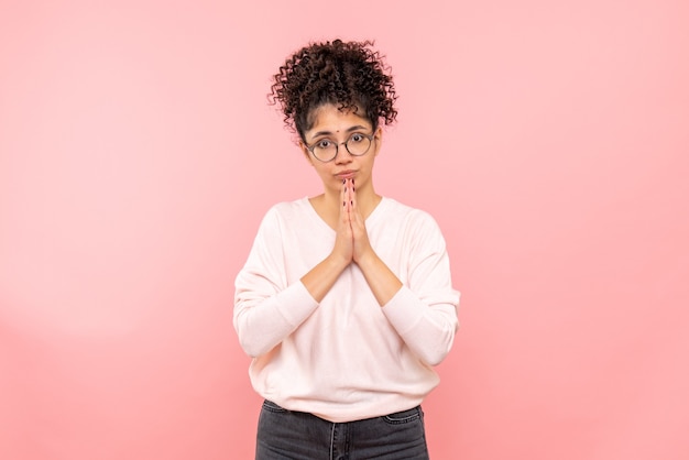 Free photo front view of young woman praying on pink wall