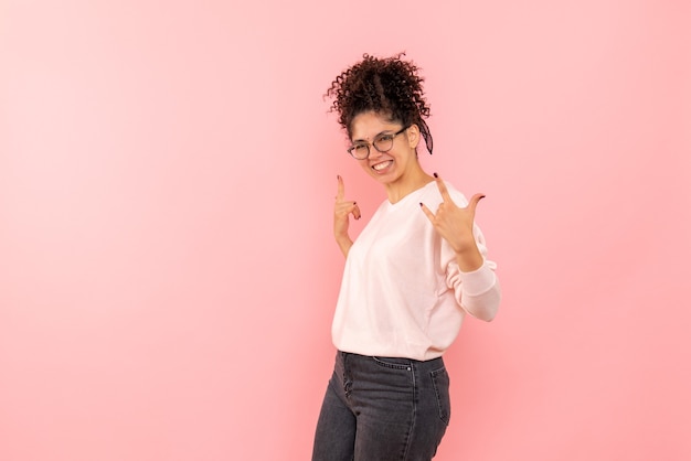 Front view of young woman rejoicing on a pink wall