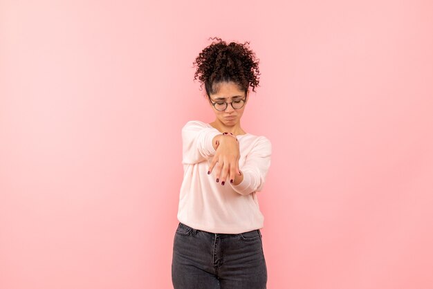 Front view of young woman sad on pink wall