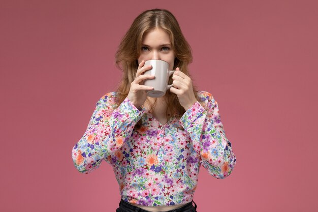 Foto gratuita giovane donna di vista frontale che sorseggia il suo caffè