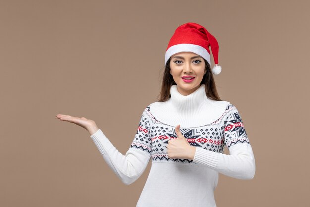 Front view young woman smiling on brown background holiday emotion christmas