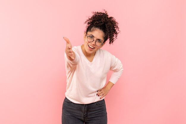 Front view of young woman smiling on a pink wall