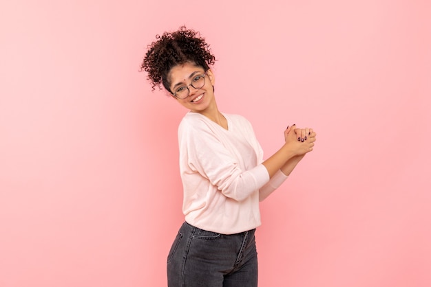 Free photo front view of young woman smiling on the pink wall