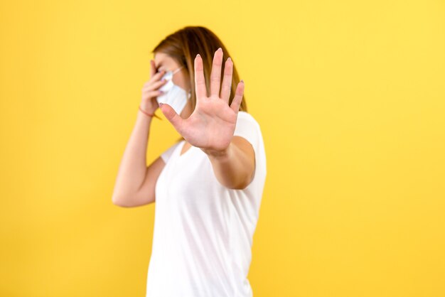 Front view of young woman stressed on yellow wall