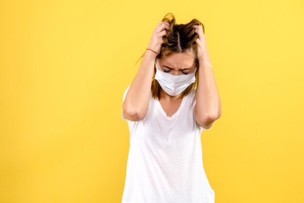 Front view of young woman stressed on yellow wall