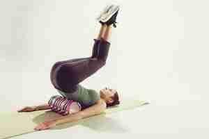 Free photo front view of a young woman stretching body in gymnastics class.