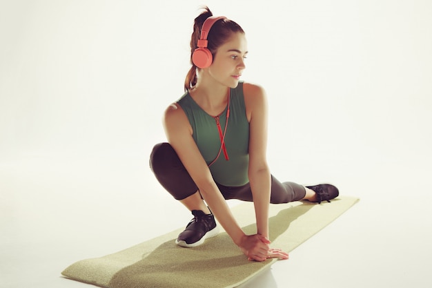 Foto gratuita vista frontale di una giovane donna che allunga corpo nella classe di ginnastica.