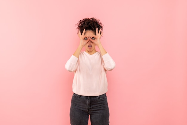 Front view of young woman surprised on pink wall