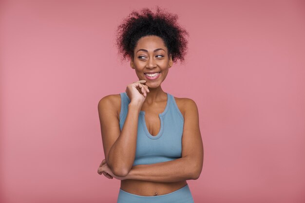 Front view of a young woman thinking about something that makes her smile