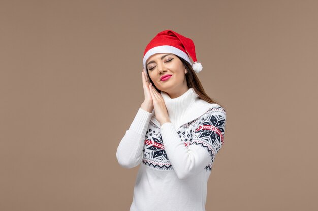 Front view young woman trying to sleep on brown background christmas emotion new year