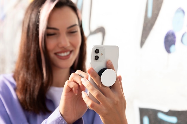 Free photo front view young woman using popsocket