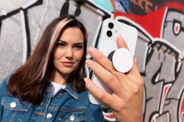 Вид спереди молодая женщина с помощью popsocket