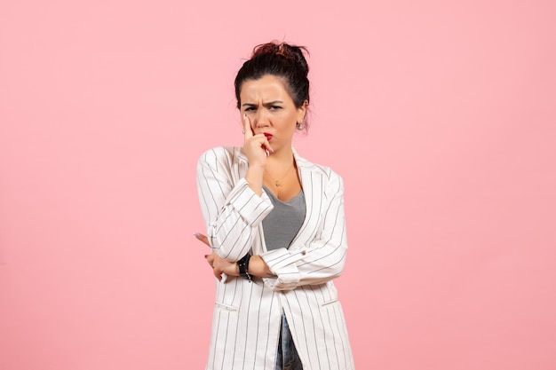 Front view young woman wearing white jacket and posing on pink background lady fashion color woman emotion