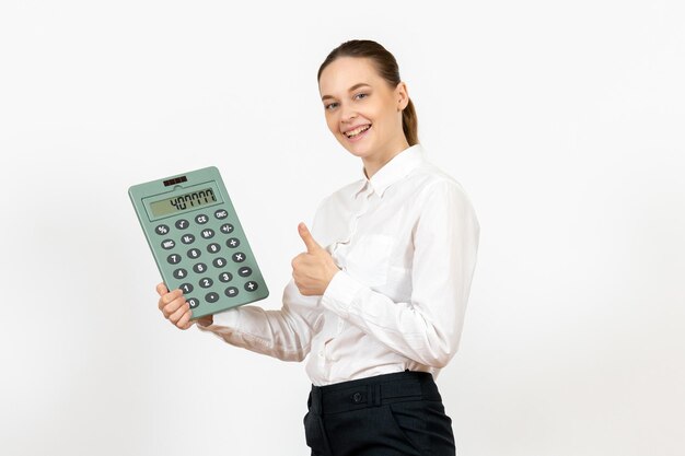 Front view young woman in white blouse holding big calculator on white desk office female emotion feeling job worker white