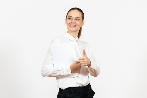Front view young woman in white blouse holding different documents and smiling on white background female emotion feeling office job