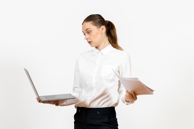 Front view young woman in white blouse holding laptop and documents on white background female job office emotions feelings model