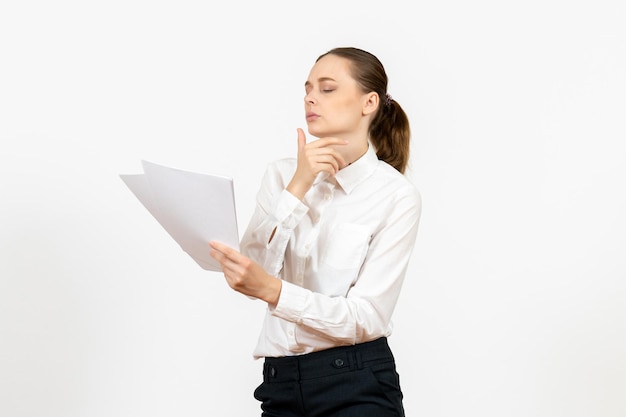 Front view young woman in white blouse holding and reading documents on white background female job emotion feeling office