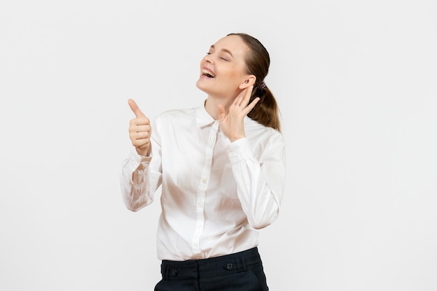 Vista frontale giovane donna in camicetta bianca che ascolta da vicino su sfondo bianco lavoro femminile ufficio emozione modello di sentimento