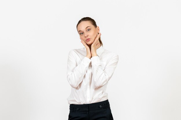 Вид спереди молодая женщина в белой блузке с кокетливым лицом на белом фоне работа в офисе женские чувства модель эмоции