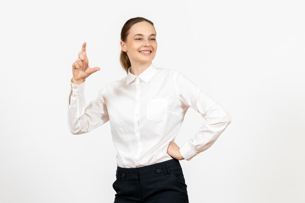 Вид спереди молодая женщина в белой блузке с улыбающимся выражением лица на белом фоне офисная работа женская эмоция чувство модели