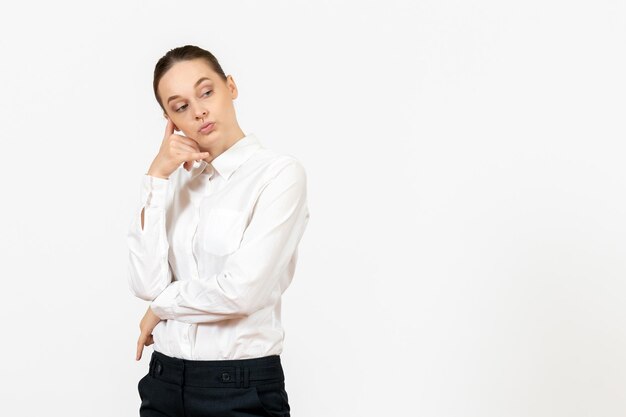 Вид спереди молодая женщина в белой блузке с выражением мышления на белом фоне, чувствуя модель офиса, эмоции, женскую работу