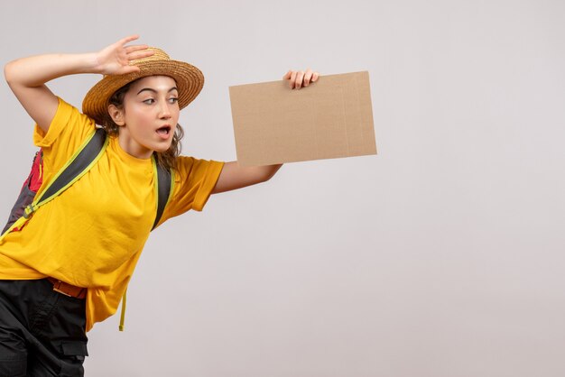 Free photo front view young woman with backpack holding cardboard