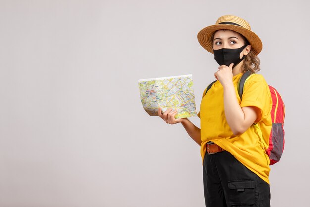 Front view young woman with backpack holding up map