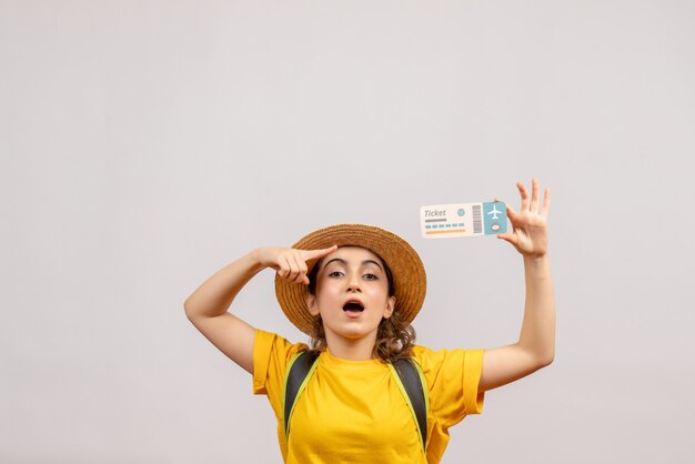 Free photo front view young woman with backpack pointing at travel ticket