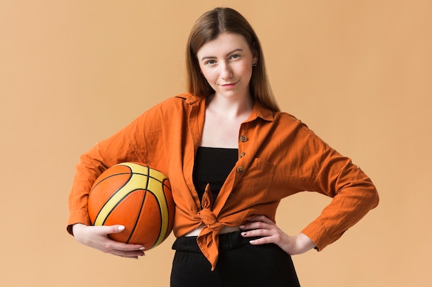 Front view young woman with basketball ball