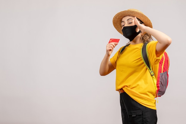 Foto gratuita vista frontale giovane donna con maschera nera che chiude gli occhi tenendo la carta