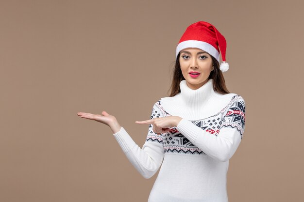 Вид спереди молодая женщина с рождественской накидкой на коричневом фоне праздничные эмоции рождество