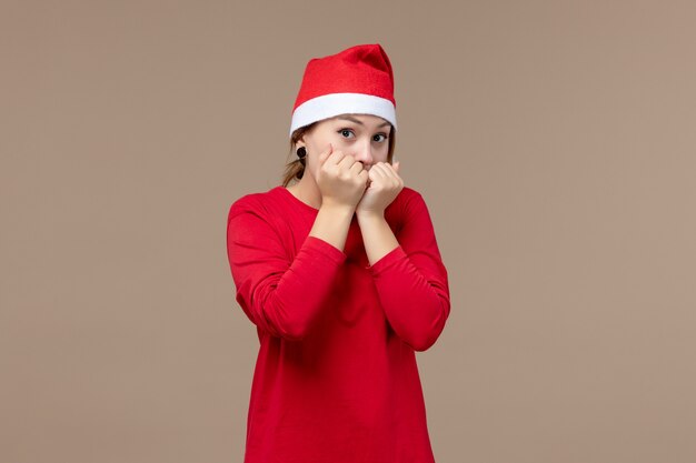 Front view of young woman with christmas cape on brown