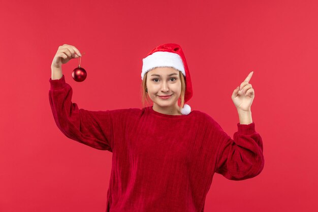 Вид спереди молодая женщина с рождественской игрушкой, рождественский праздник эмоций