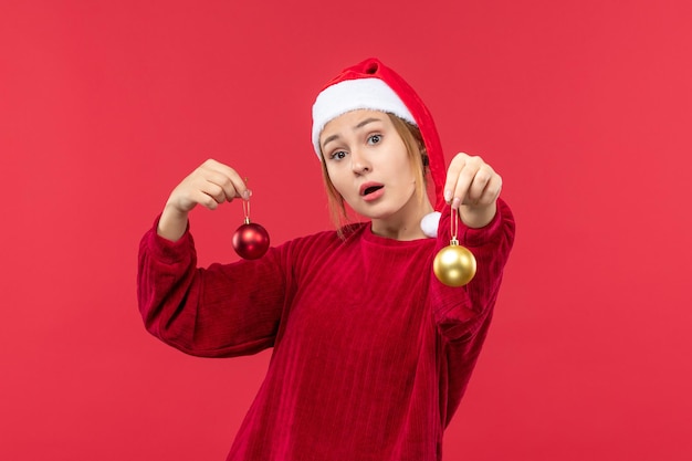 Вид спереди молодая женщина с рождественскими игрушками, рождественский праздник эмоций