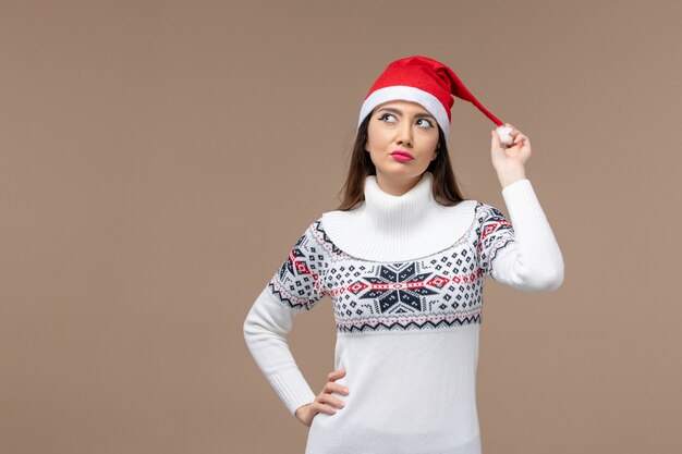 Front view young woman with dreaming expression on brown background new year emotions christmas