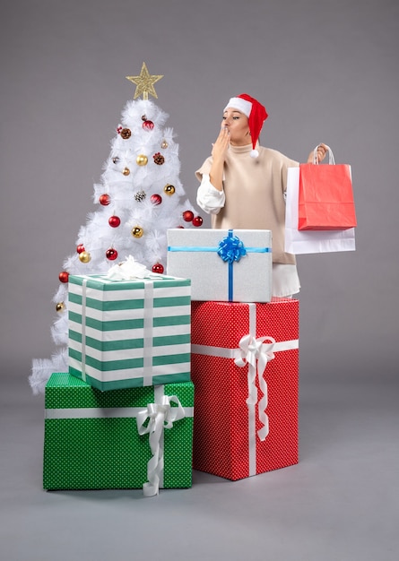 Free photo front view young woman with holiday presents on the grey