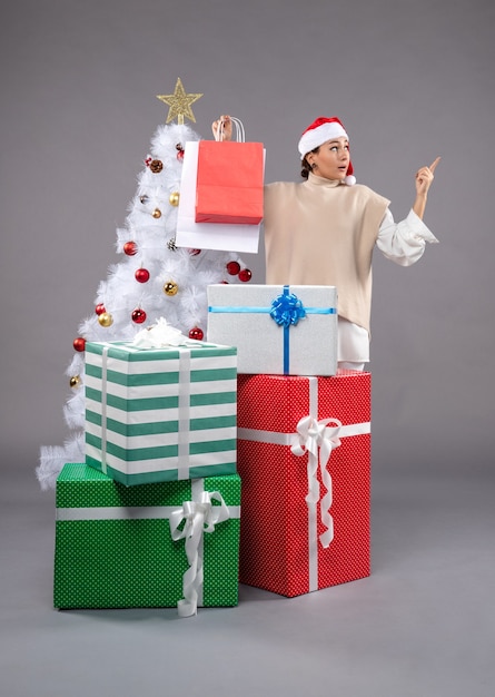 Front view young woman with holiday presents on light desk female new year xmas