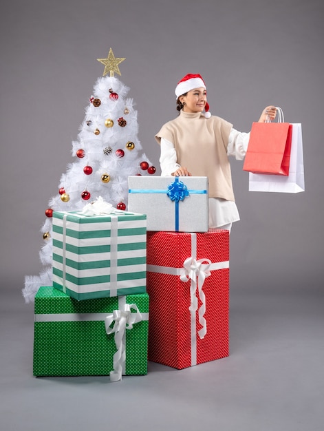 Free photo front view young woman with holiday presents on light