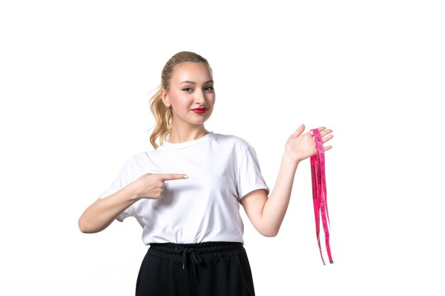 Front view young woman with measure tape on white surface