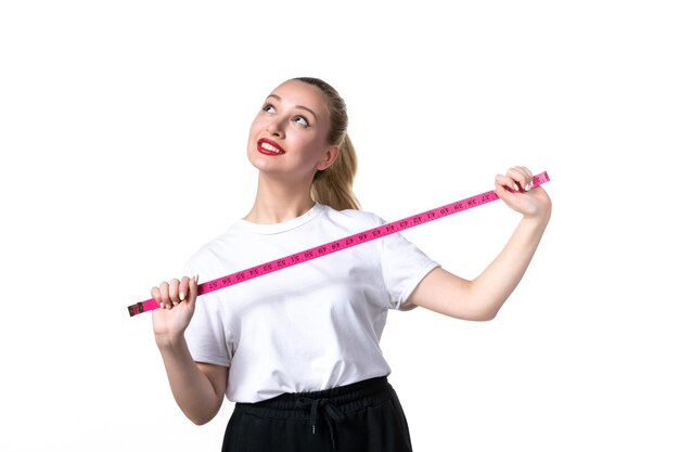 Front view young woman with measure tape on white surface