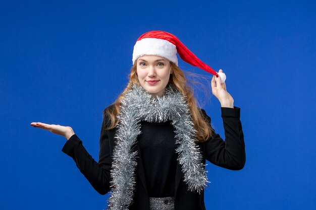 Front view of young woman with New Year's garlands on a blue wall