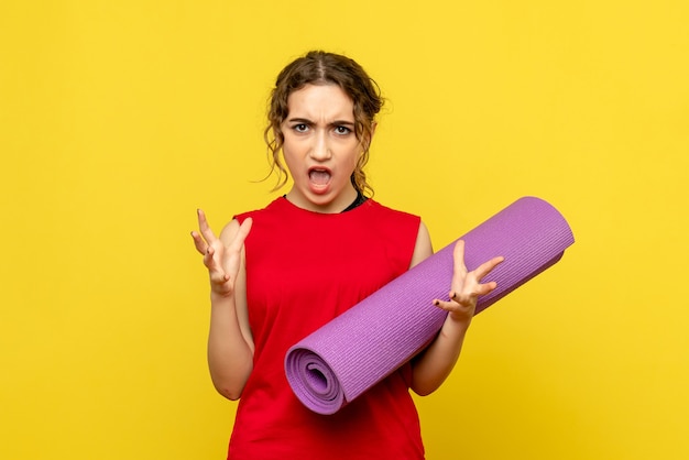 Free photo front view of young woman with purple carpet on yellow wall