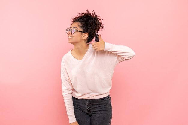 Front view of young woman with smile on pink wall